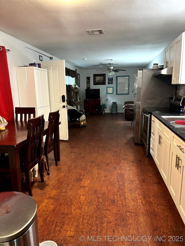 24 Lakeside, Adair, OK 74330 - kitchen with stainless steel electric range, a ceiling fan, dark wood finished floors, dark countertops, and white cabinetry