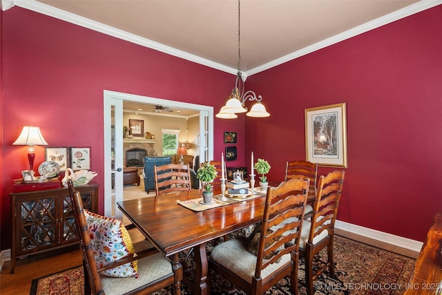 18 Longacre Dr, Ramona, OK 74061 - dining room featuring ornamental molding, wood finished floors, a fireplace, and a chandelier