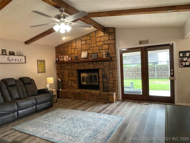 3800 S Narcissus Ave, Broken Arrow, OK 74011 - living area with a stone fireplace, wood finished floors, ceiling fan, and a textured ceiling