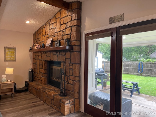 3800 S Narcissus Ave, Broken Arrow, OK 74011 - living room with wood finished floors, a stone fireplace, and a textured ceiling