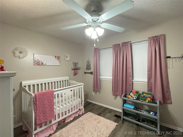 3800 S Narcissus Ave, Broken Arrow, OK 74011 - bedroom featuring a nursery area, wood finished floors, a textured ceiling, and a ceiling fan