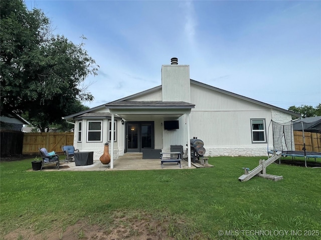 3800 S Narcissus Ave, Broken Arrow, OK 74011 - rear view of house featuring a trampoline, a patio, and a chimney