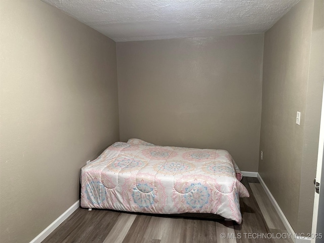 8201 State Highway 20, Eucha, OK 74342 - bedroom with wood finished floors and a textured ceiling