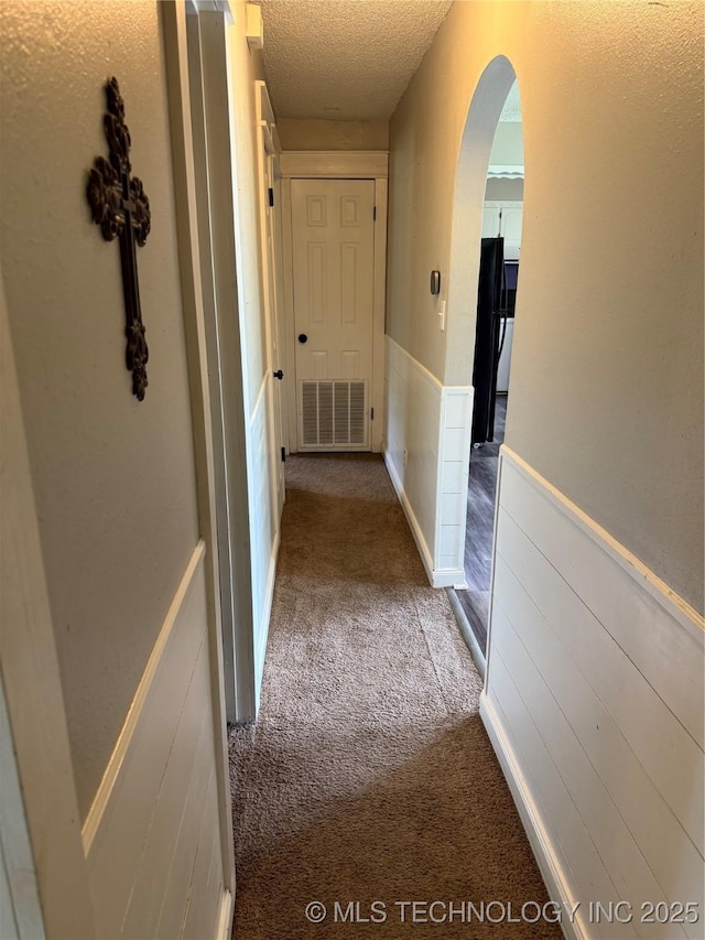303 N 6th, Calera, OK 74730 - corridor with carpet, arched walkways, and a textured ceiling