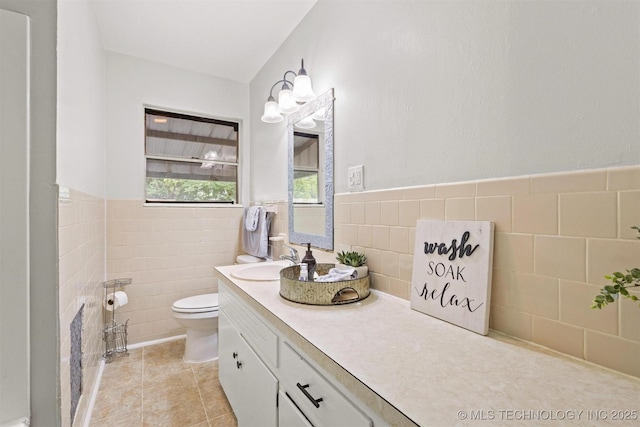 707 Bradwell St, Colbert, OK 74733 - bathroom with tile walls, vanity, a wainscoted wall, and tile patterned floors