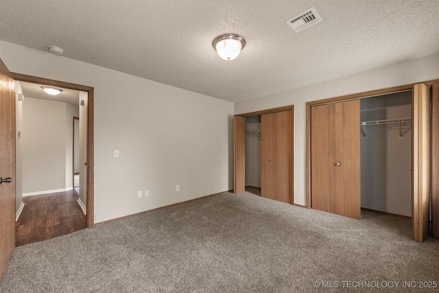 9207 S 92nd E Ave, Tulsa, OK 74133 - unfurnished bedroom featuring two closets, carpet flooring, and a textured ceiling