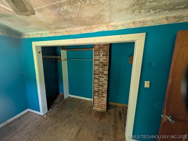 468446 E 908th Rd, Bunch, OK 74931 - unfurnished bedroom with wood finished floors and a closet