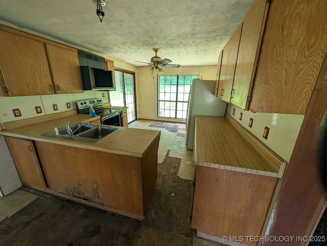 468446 E 908th Rd, Bunch, OK 74931 - kitchen with electric range, freestanding refrigerator, a peninsula, light countertops, and a textured ceiling