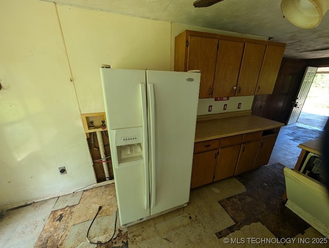 468446 E 908th Rd, Bunch, OK 74931 - kitchen featuring white fridge with ice dispenser, brown cabinets, and light countertops
