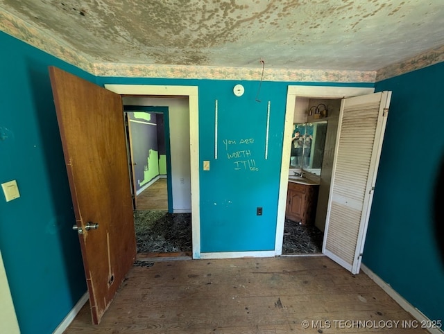 468446 E 908th Rd, Bunch, OK 74931 - unfurnished bedroom featuring baseboards and wood finished floors