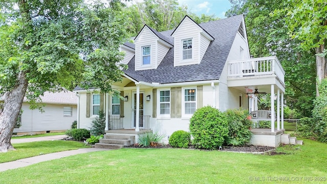 1312 S Oak, Ada, OK 74820 - view of front of house featuring a shingled roof, a front yard, ceiling fan, a balcony, and a porch