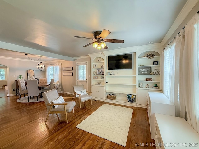 1312 S Oak, Ada, OK 74820 - living area featuring ornamental molding, dark wood-type flooring, plenty of natural light, ceiling fan, and built in shelves