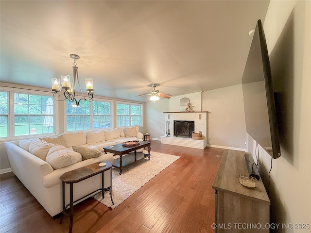 1312 S Oak, Ada, OK 74820 - living area with wood finished floors, a ceiling fan, a chandelier, and a fireplace