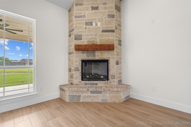 150 Chateau Bnd, Ardmore, OK 73401 - unfurnished living room with a stone fireplace, wood finished floors, and a ceiling fan