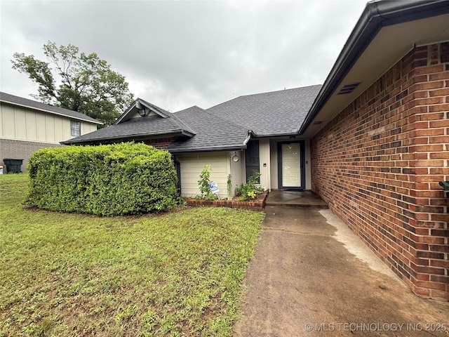 2802 Georgia, Muskogee, OK 74403 - view of exterior entry with roof with shingles, a lawn, and brick siding