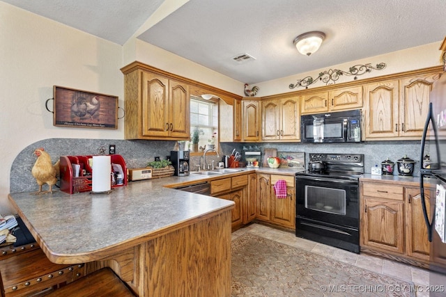 447247 E 70th Rd, Welch, OK 74369 - kitchen with black appliances, a peninsula, backsplash, a kitchen breakfast bar, and brown cabinetry