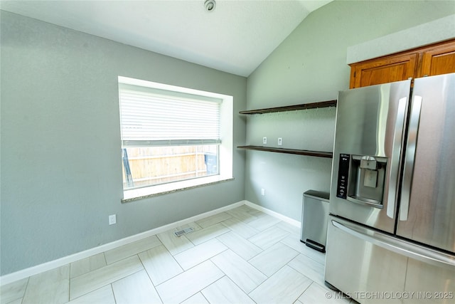 7224 NW 102nd, Oklahoma City, OK 73162 - kitchen featuring stainless steel fridge, vaulted ceiling, and brown cabinets