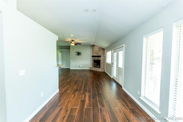 7224 NW 102nd, Oklahoma City, OK 73162 - unfurnished living room with vaulted ceiling, a fireplace, ceiling fan, and dark wood finished floors
