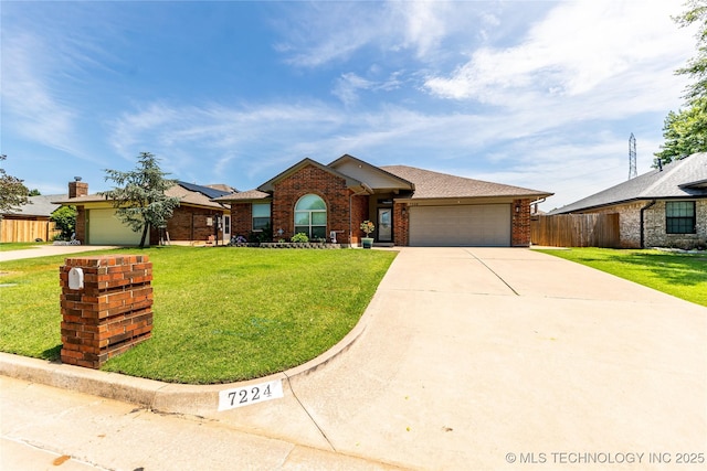 7224 NW 102nd, Oklahoma City, OK 73162 - view of front facade with an attached garage, concrete driveway, brick siding, roof mounted solar panels, and roof with shingles
