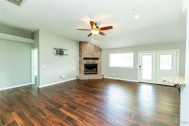7224 NW 102nd, Oklahoma City, OK 73162 - unfurnished living room with vaulted ceiling, a ceiling fan, a brick fireplace, and dark wood-style flooring