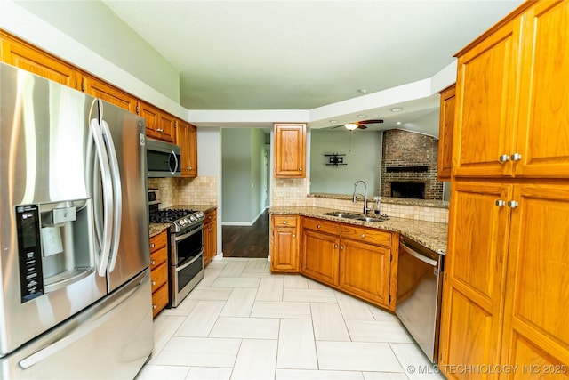 7224 NW 102nd, Oklahoma City, OK 73162 - kitchen with appliances with stainless steel finishes, a brick fireplace, ceiling fan, backsplash, and brown cabinetry