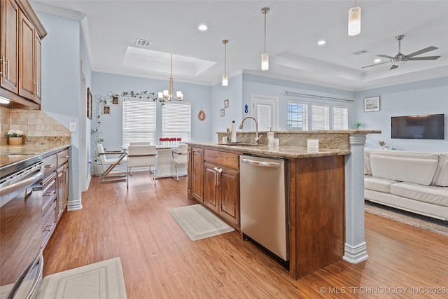 303 Hidden Path, Ardmore, OK 73401 - kitchen featuring a raised ceiling, stainless steel appliances, open floor plan, light wood finished floors, and a chandelier