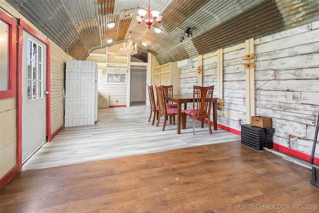 14820 Memorial, Wilson, OK 73463 - dining room featuring a chandelier, vaulted ceiling, wood finished floors, and wooden walls