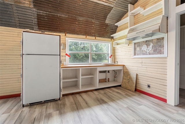 14820 Memorial, Wilson, OK 73463 - kitchen featuring freestanding refrigerator, wooden walls, wood finished floors, lofted ceiling, and wood ceiling