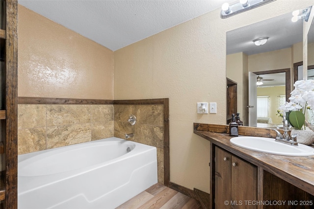 14820 Memorial, Wilson, OK 73463 - bathroom with a garden tub, wood finished floors, vanity, a textured wall, and a ceiling fan