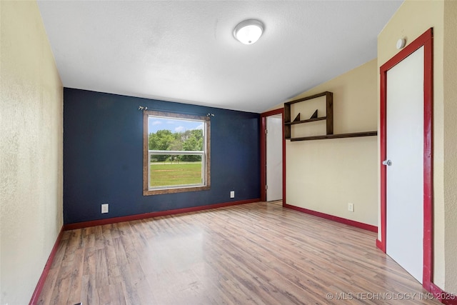 14820 Memorial, Wilson, OK 73463 - empty room with wood finished floors and vaulted ceiling