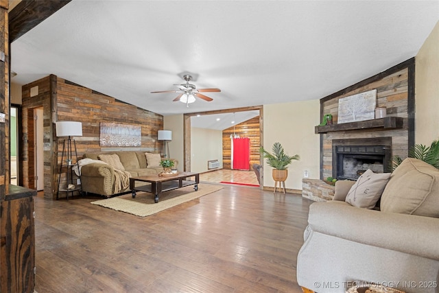 14820 Memorial, Wilson, OK 73463 - living room featuring a large fireplace, wooden walls, a ceiling fan, wood finished floors, and lofted ceiling