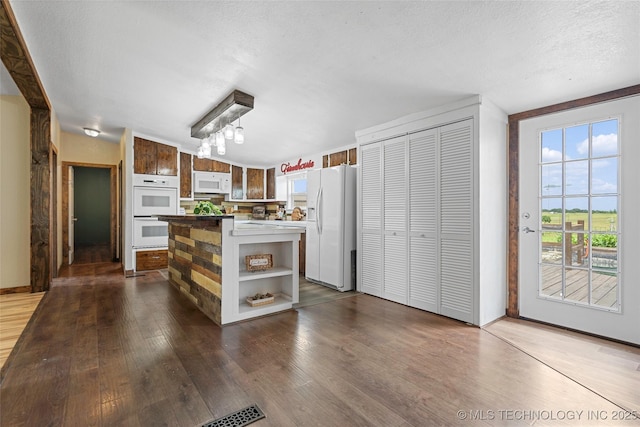 14820 Memorial, Wilson, OK 73463 - kitchen featuring white appliances, open shelves, dark wood finished floors, a center island, and a textured ceiling