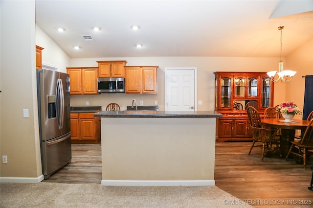 614 S Seminole St, Skiatook, OK 74070 - kitchen featuring appliances with stainless steel finishes, a chandelier, vaulted ceiling, a kitchen island, and pendant lighting