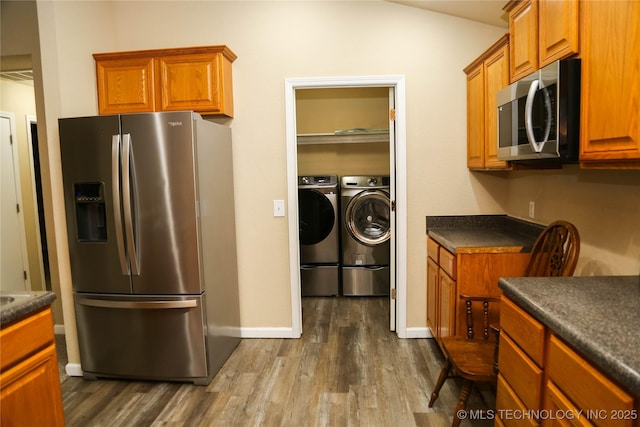 614 S Seminole St, Skiatook, OK 74070 - kitchen with appliances with stainless steel finishes, separate washer and dryer, dark countertops, dark wood-style flooring, and brown cabinets