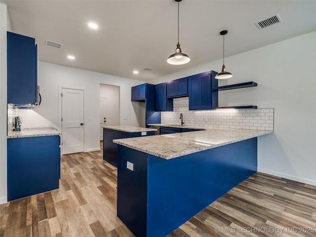 7 Port Duncan Blvd, Afton, OK 74331 - kitchen with a peninsula, blue cabinetry, light wood-style floors, decorative backsplash, and recessed lighting