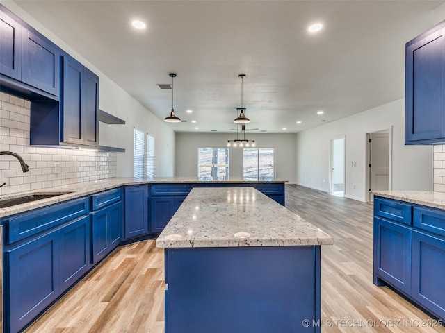 7 Port Duncan Blvd, Afton, OK 74331 - kitchen with blue cabinets, a peninsula, decorative backsplash, light wood-style flooring, and open shelves