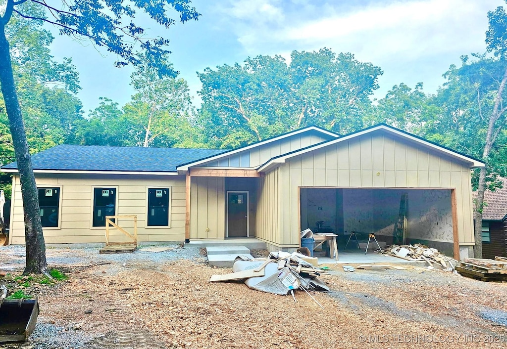 4 Tulsa Dr, Monkey Island, OK 74331 - view of front of property featuring an attached garage, board and batten siding, dirt driveway, and a shingled roof