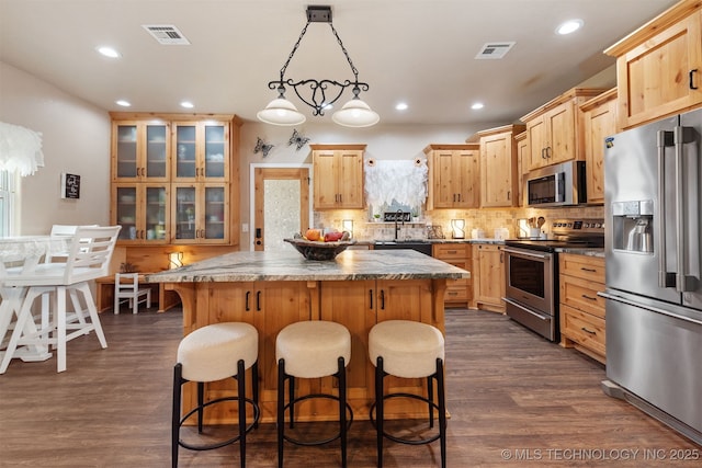 20672 E Kambrie St, Inola, OK 74036 - kitchen featuring appliances with stainless steel finishes, a kitchen island, dark wood-style floors, glass insert cabinets, and recessed lighting