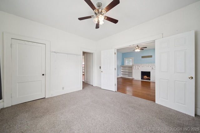 1414 E 8th St, Okmulgee, OK 74447 - unfurnished bedroom featuring carpet flooring, a lit fireplace, and ceiling fan