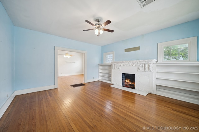 1414 E 8th St, Okmulgee, OK 74447 - unfurnished living room with ceiling fan, a fireplace with flush hearth, and hardwood / wood-style floors