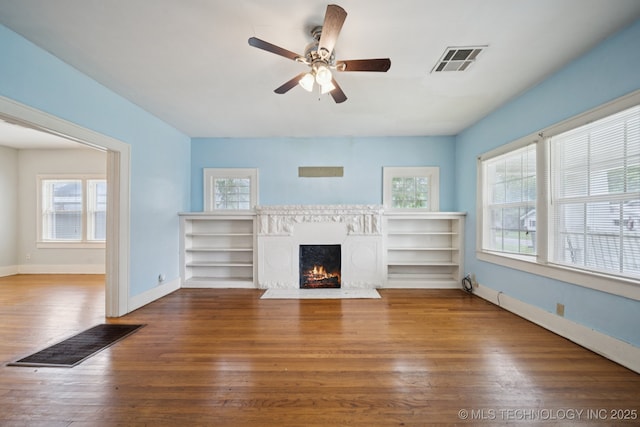 1414 E 8th St, Okmulgee, OK 74447 - living room with wood finished floors, a fireplace with flush hearth, and ceiling fan