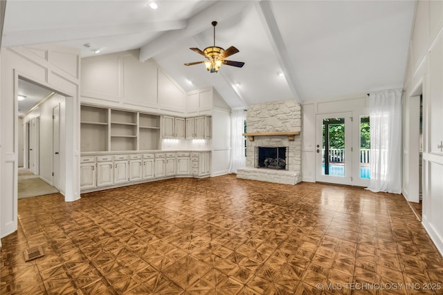 9916 S Quebec Ave, Tulsa, OK 74137 - unfurnished living room with ceiling fan, a fireplace, beamed ceiling, high vaulted ceiling, and a decorative wall