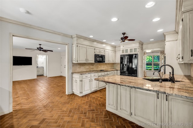9916 S Quebec Ave, Tulsa, OK 74137 - kitchen featuring black appliances, ceiling fan, a peninsula, tasteful backsplash, and light stone counters