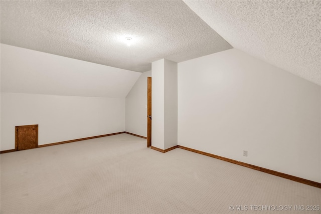 9916 S Quebec Ave, Tulsa, OK 74137 - additional living space featuring lofted ceiling, light carpet, and a textured ceiling