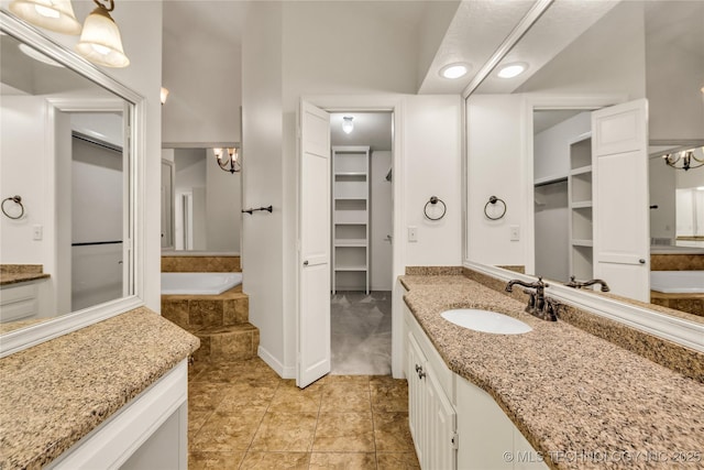 9916 S Quebec Ave, Tulsa, OK 74137 - bathroom with vanity, a chandelier, a spacious closet, a garden tub, and tile patterned floors