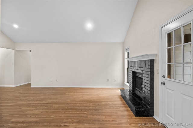 8903 N 124th E Ave, Owasso, OK 74055 - unfurnished living room featuring lofted ceiling, a brick fireplace, wood finished floors, and recessed lighting