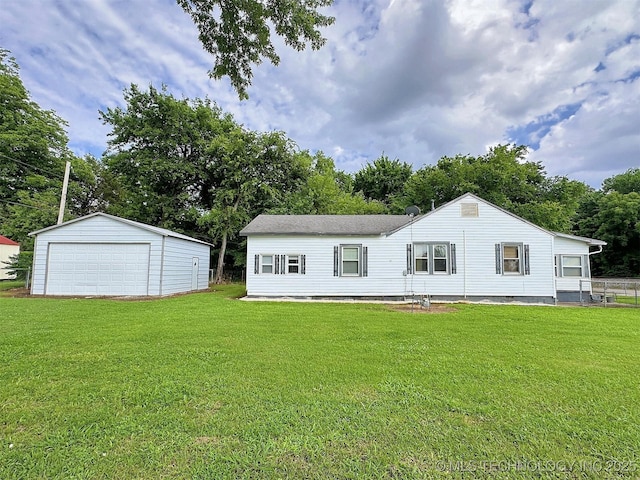 616 N Lee St, Fort Gibson, OK 74434 - back of house featuring a detached garage, a lawn, an outbuilding, and view of wooded area