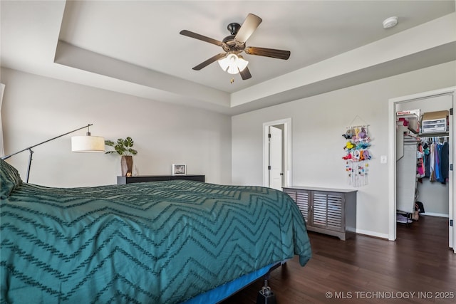 4661 E 148th St S, Bixby, OK 74008 - bedroom featuring wood finished floors, a walk in closet, a raised ceiling, a closet, and a ceiling fan