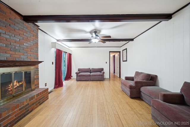 6922 E 16th St, Tulsa, OK 74112 - living room featuring beamed ceiling, ceiling fan, wood finished floors, and a fireplace