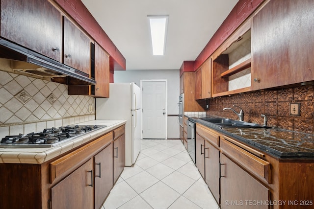 6922 E 16th St, Tulsa, OK 74112 - kitchen with stainless steel gas cooktop, freestanding refrigerator, tasteful backsplash, dishwasher, and light tile patterned flooring